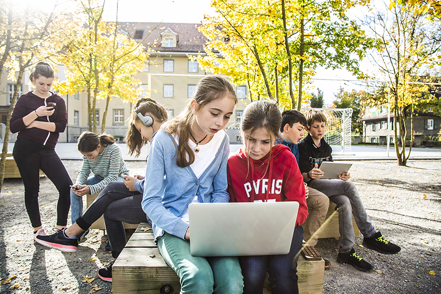 Les jeunes ont besoin des appareils mobiles dans la cour de récréation.