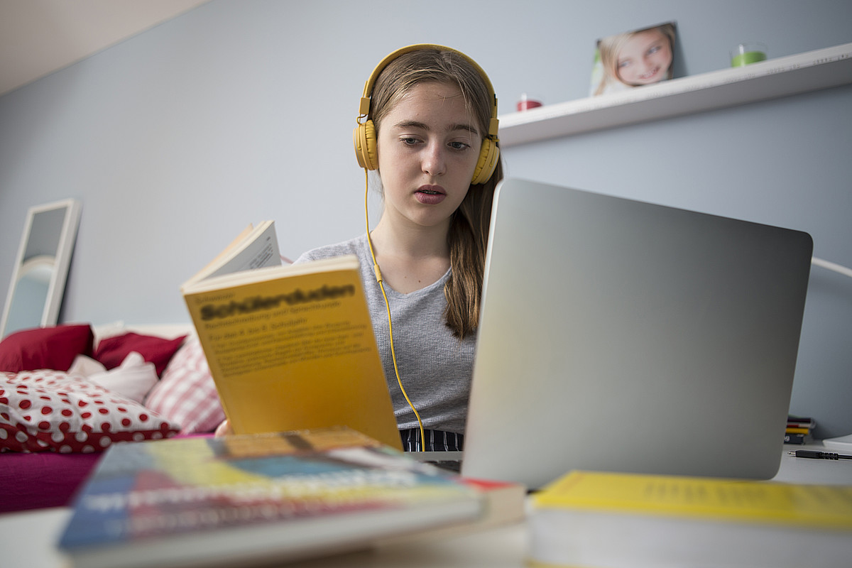 Une adolescente apprend avec l'ordinateur portable à son bureau.