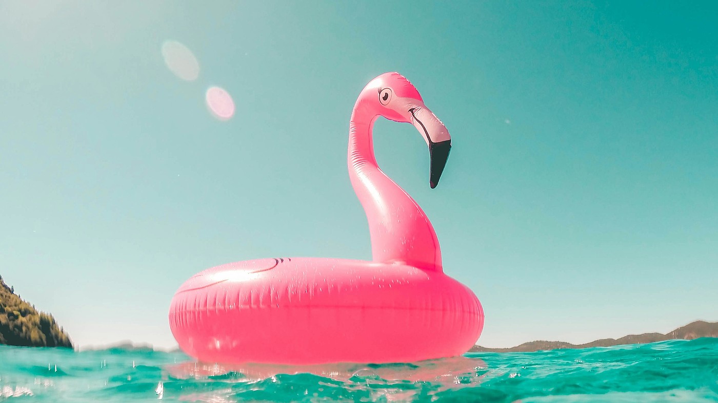 Anneau de natation flamant rose sur l'eau