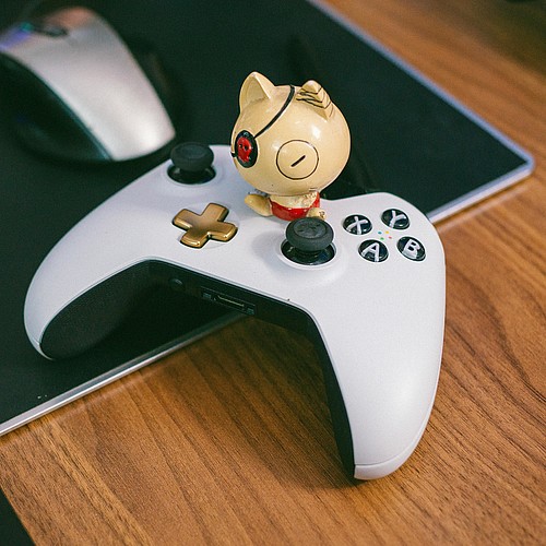 Manette de jeu blanche et noire sur un bureau avec un personnage de bande dessinée