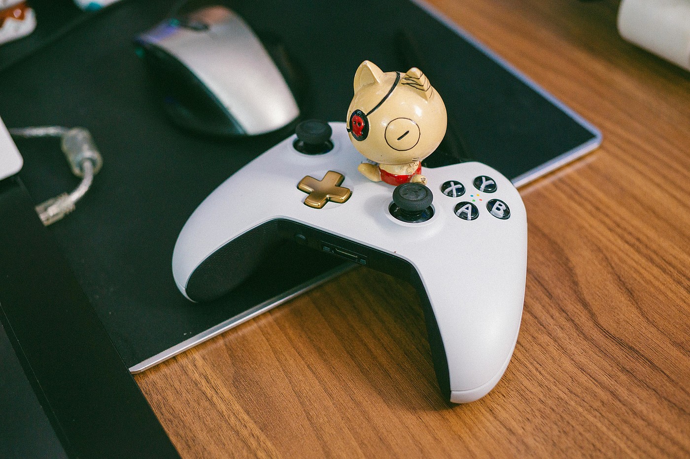 Manette de jeu blanche et noire sur un bureau avec un personnage de bande dessinée