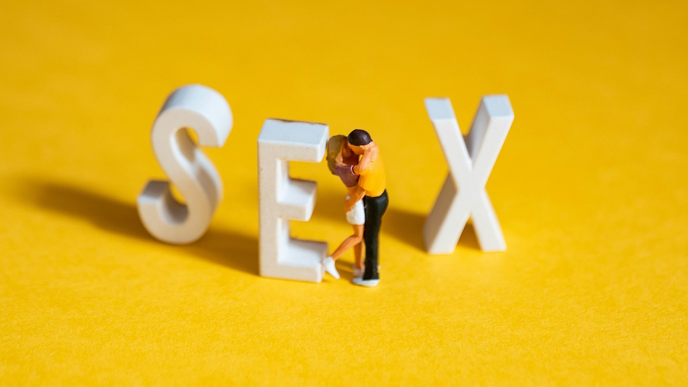 Deux petits personnages s'enlaçant et les lettres S-E-X.