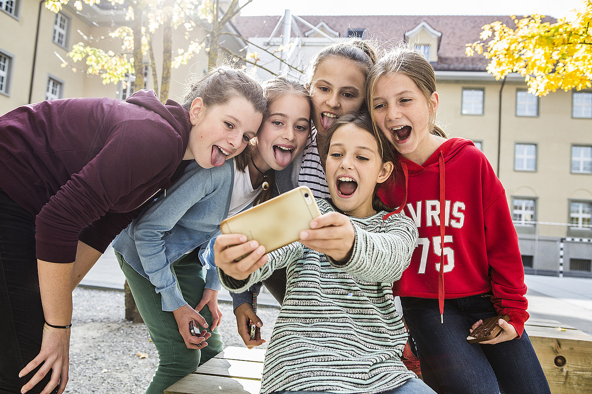 Cinq adolescentes prenant un selfie.