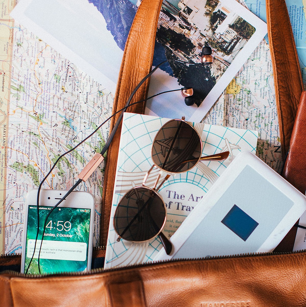 [Translate to Französisch:] Tasche mit Reisesachen und Smartphone