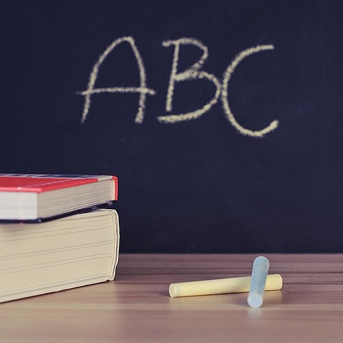 Tableau noir avec les lettres A, B et C, livres et craie
