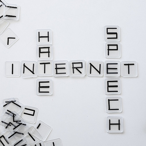 Sur la table se trouvent les mots "haine", "internet" et "discours".