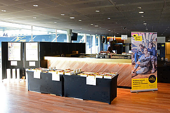 Deux tables noires dans le stade du Wankdorf avec des brochures sur les jeunes et les médias.