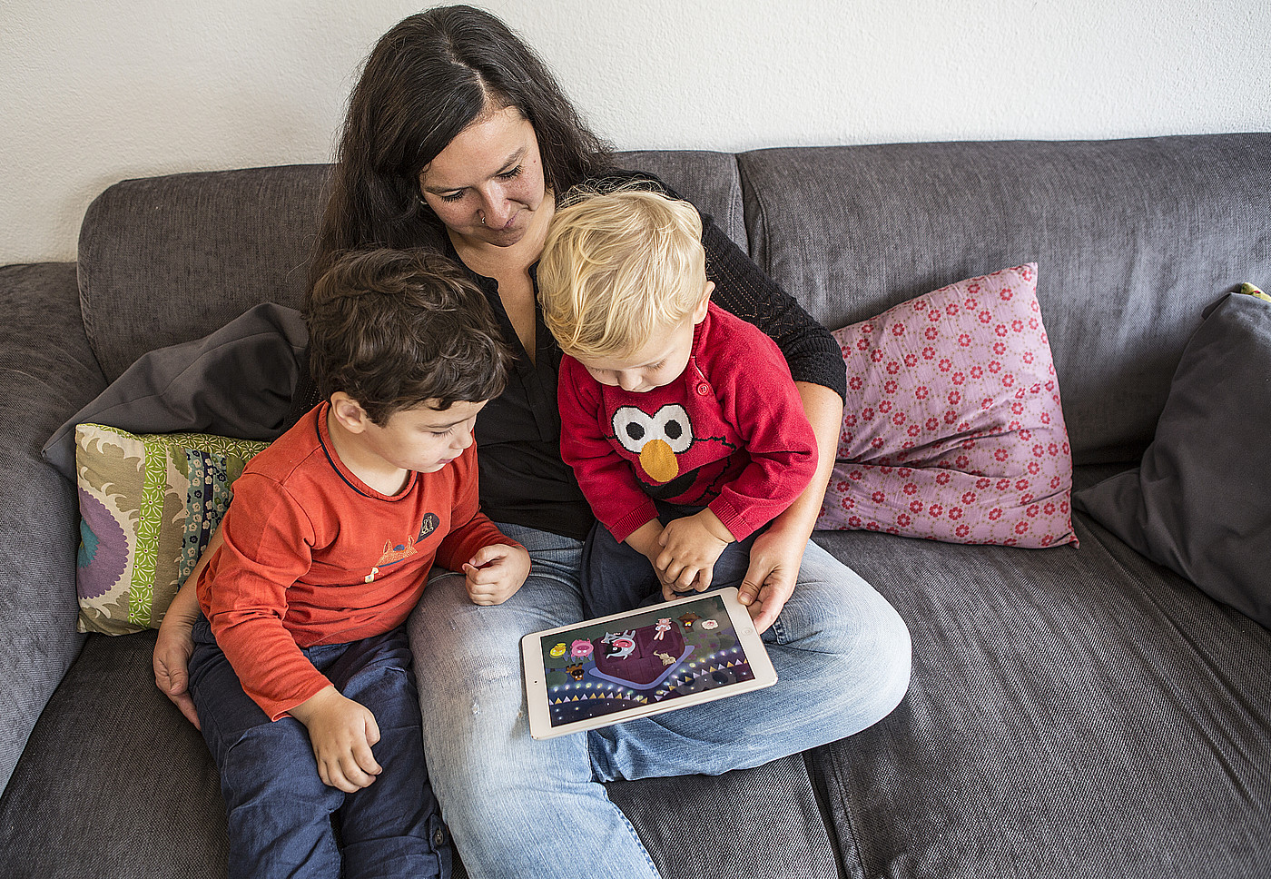 Une femme montre un film aux enfants sur une tablette.