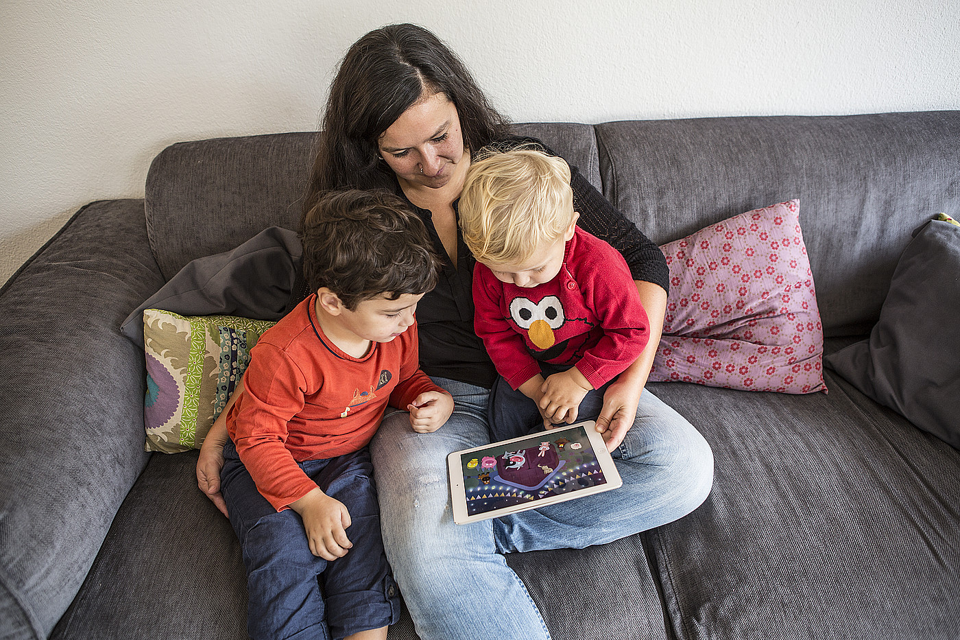 Une femme montre un film aux enfants sur une tablette.