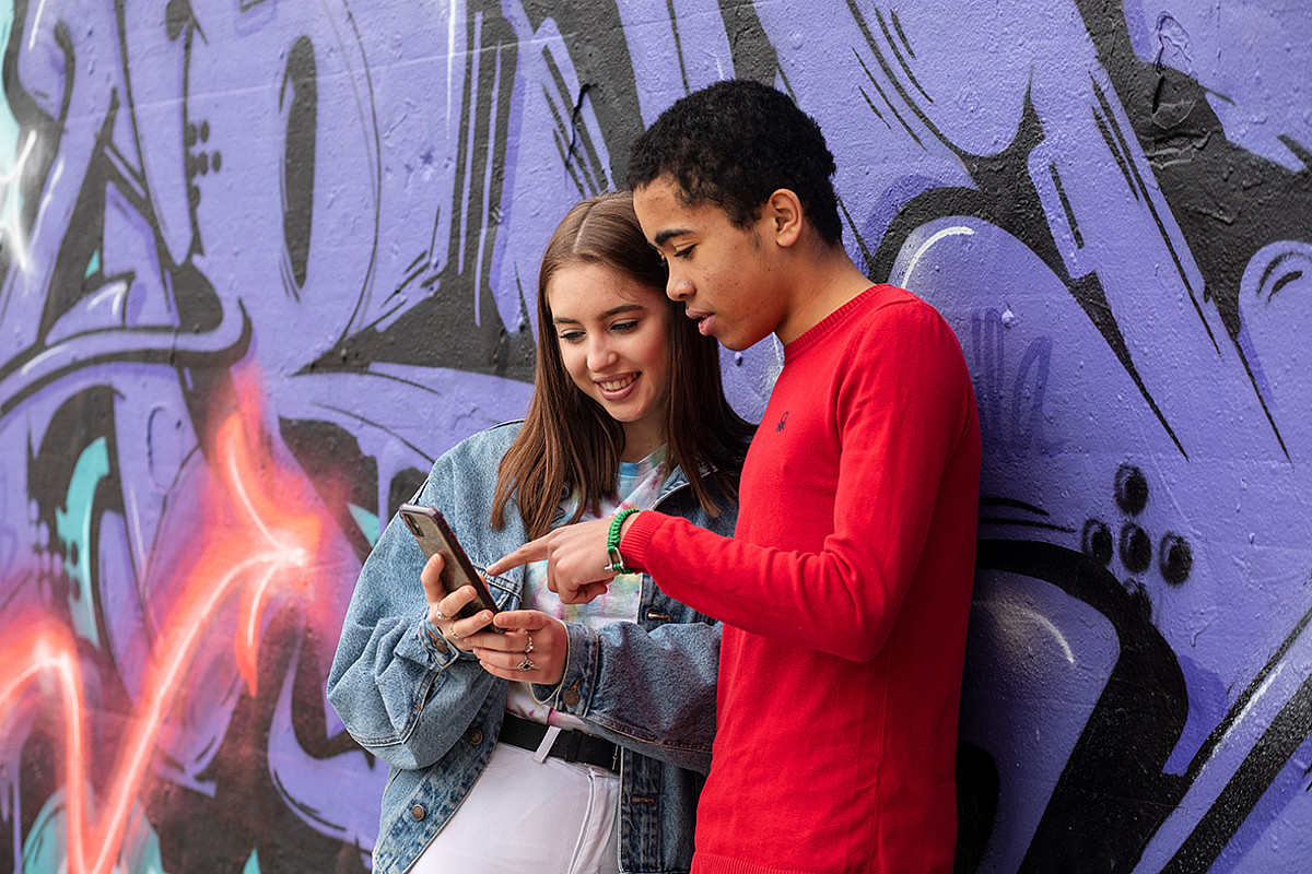 Deux adolescents regardant ensemble un smartphone.