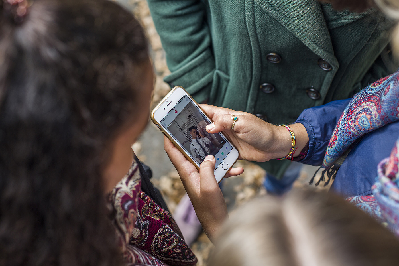 Des jeunes femmes regardent la photo de profil d'un jeune homme.