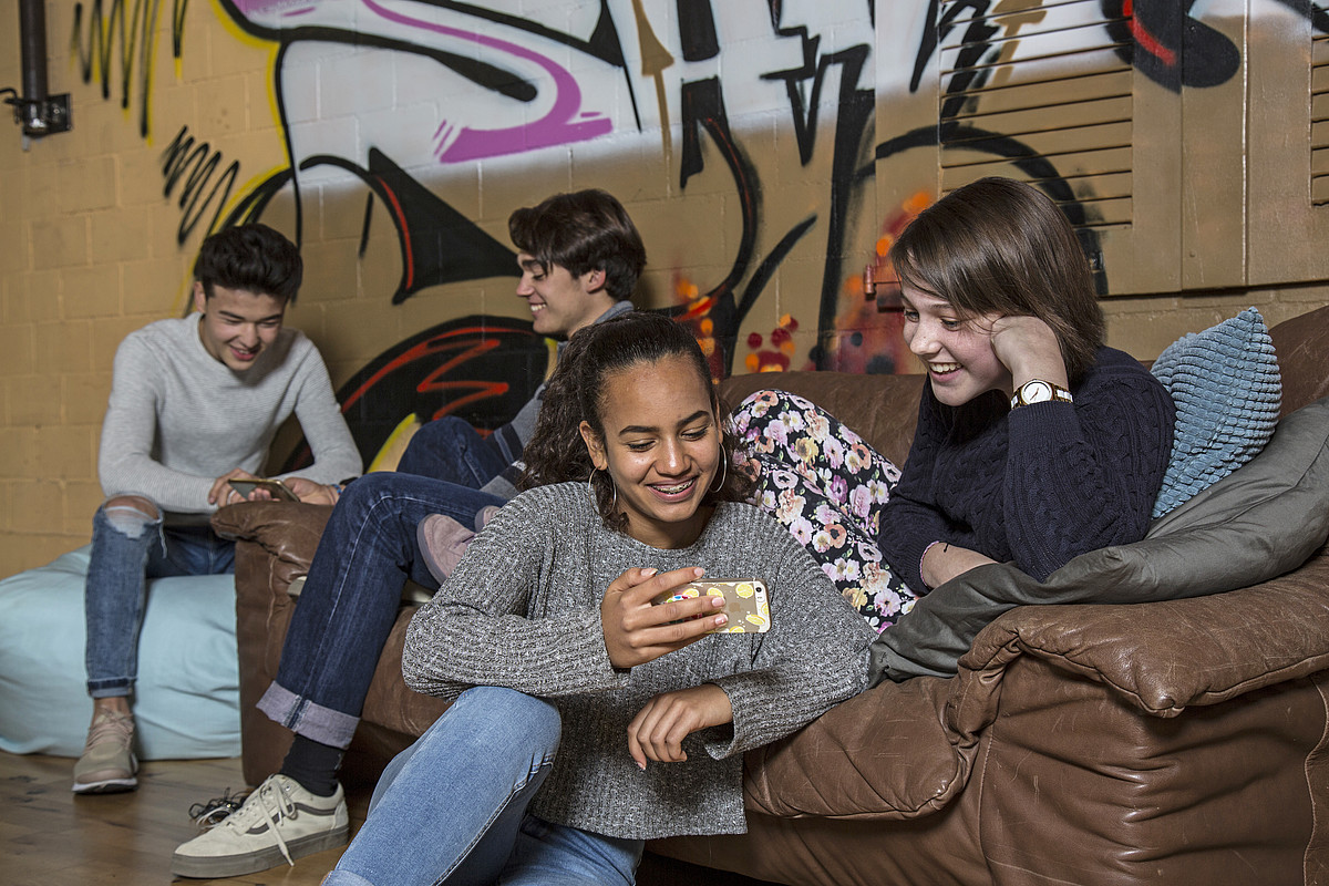 Des jeunes gens heureux passant du temps ensemble sur leur téléphone portable
